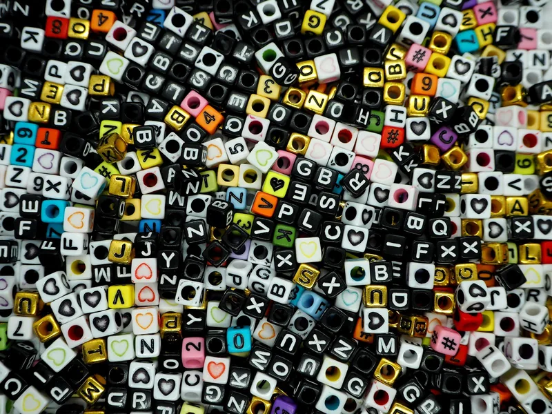 文字の入った小さな立方体のビーズが、たくさん散らばっている写真