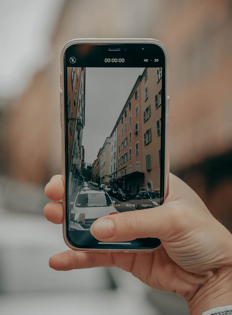 スマートフォンで街並みの動画を撮影している手元。TikTok に投稿する動画のイメージ