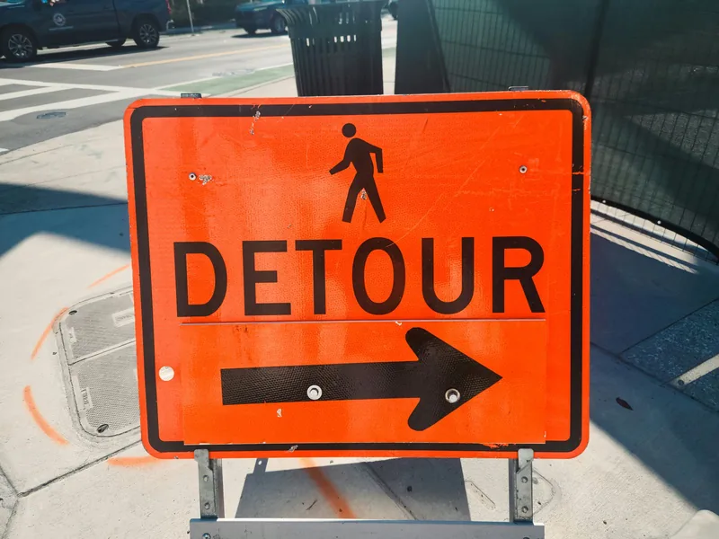 オレンジ色の「DETOUR」と矢印の標識の写真